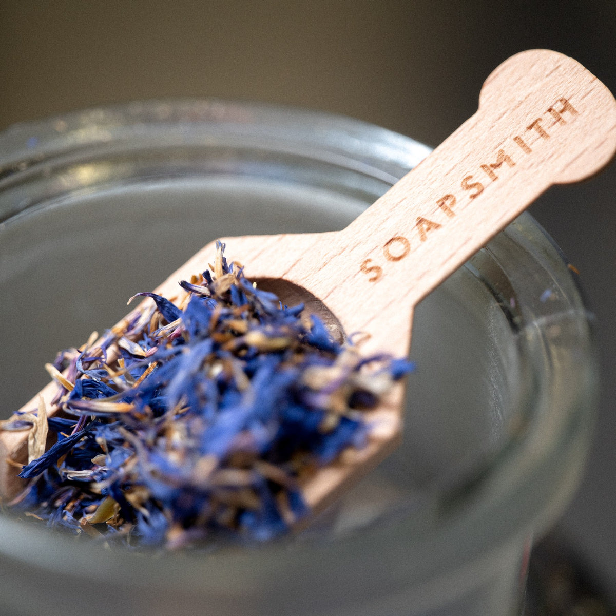 Dried botanicals on a wooden Soapsmith scoop