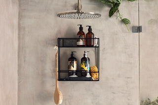 Hackney Marsh and Marble Arch Body Wash with lather on a black shower rack beneath a rainfall shower.