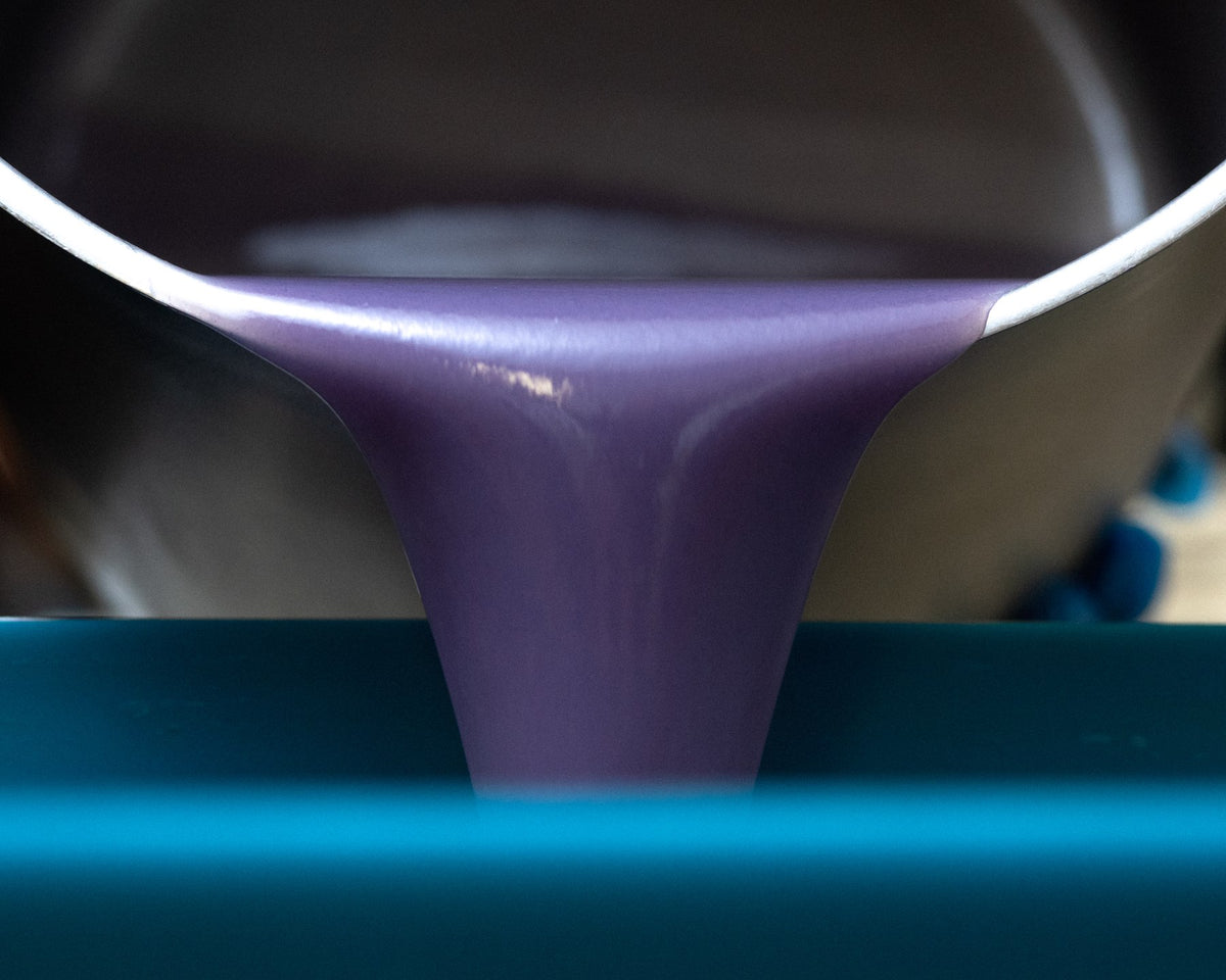 Purple soap being poured into a mould
